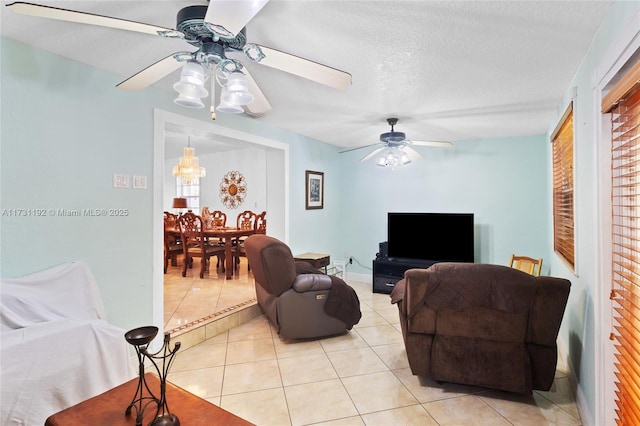 tiled living room with ceiling fan and a textured ceiling