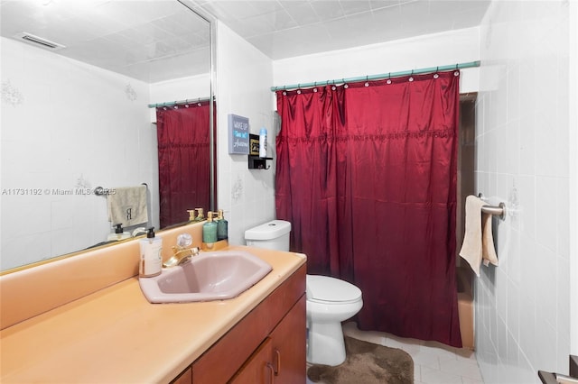 full bath featuring toilet, tile patterned floors, curtained shower, vanity, and tile walls