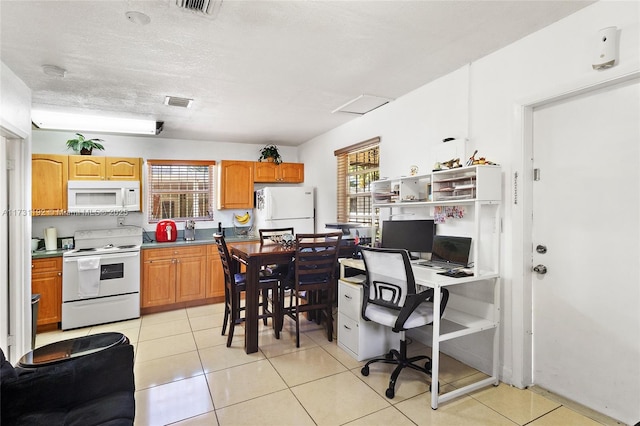 kitchen featuring white appliances, light tile patterned floors, visible vents, and a textured ceiling