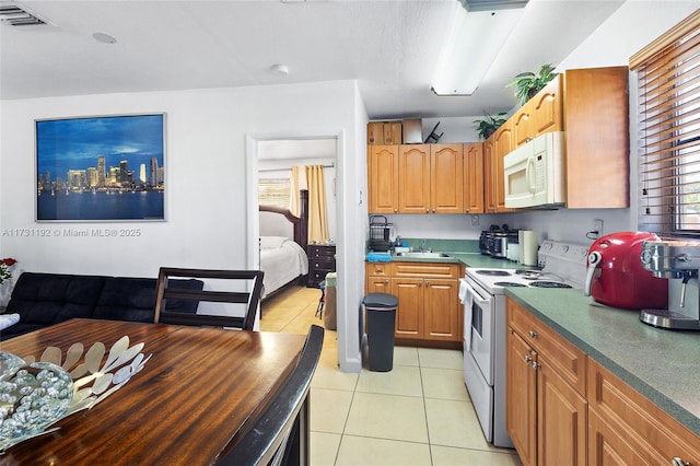 kitchen featuring a wealth of natural light, white appliances, visible vents, and light tile patterned floors