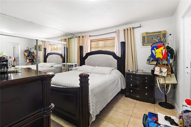 bedroom with light tile patterned floors and a wall mounted air conditioner