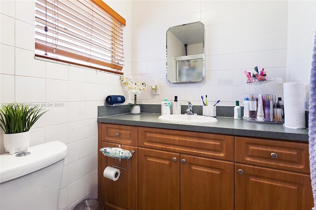 bathroom featuring vanity, tile walls, backsplash, and toilet