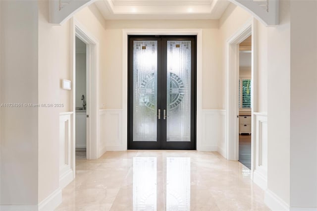 foyer entrance with french doors and ornamental molding