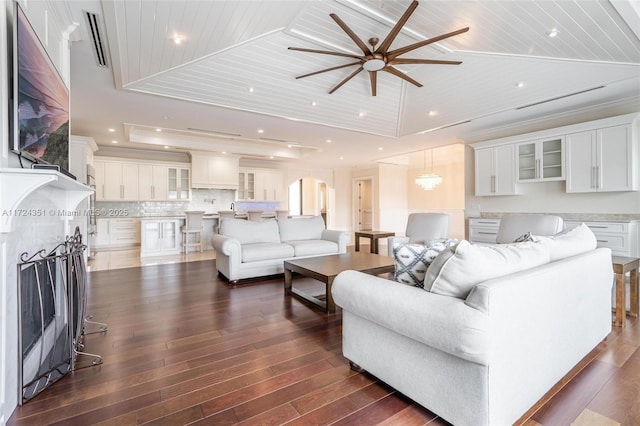 living room with wood ceiling, dark wood-type flooring, ceiling fan, a tray ceiling, and vaulted ceiling