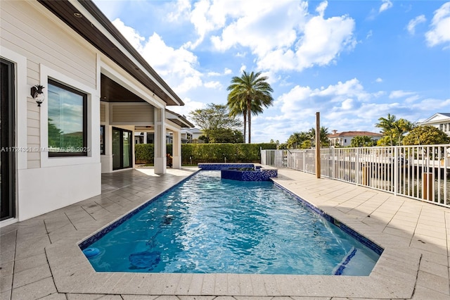 view of swimming pool featuring a patio area and an in ground hot tub