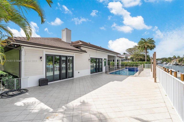 view of swimming pool featuring a patio and a water view