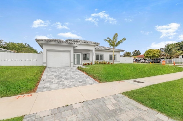 mediterranean / spanish home featuring a garage and a front lawn