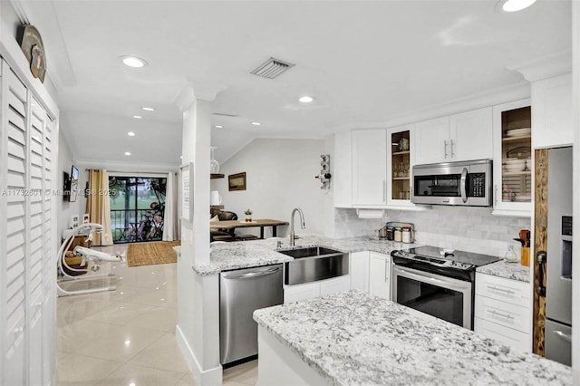 kitchen with sink, white cabinetry, stainless steel appliances, light stone countertops, and backsplash