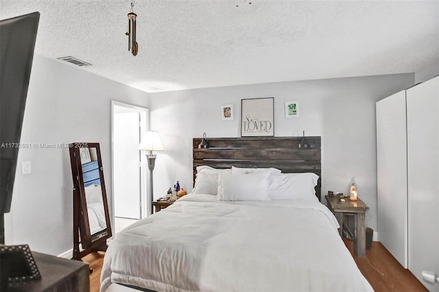 bedroom with wood-type flooring and a textured ceiling