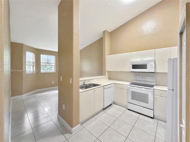 kitchen with sink, white appliances, light tile patterned floors, white cabinetry, and vaulted ceiling