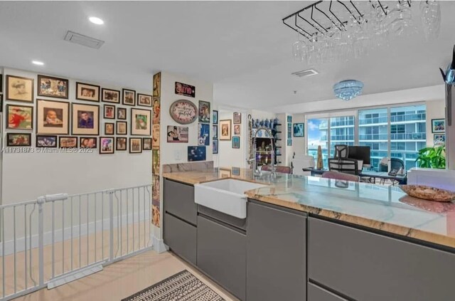 kitchen featuring sink, gray cabinets, and light tile patterned flooring