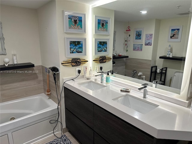 bathroom with vanity and a washtub