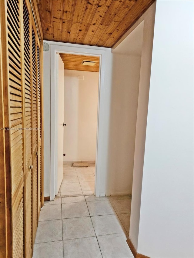 hallway with light tile patterned floors and wood ceiling