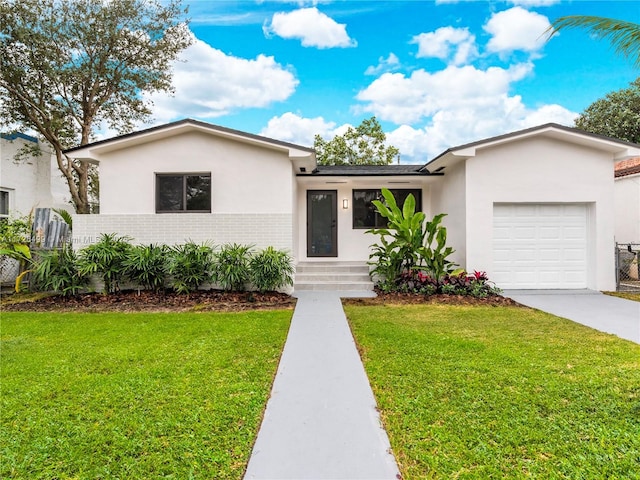 view of front of house featuring a garage and a front lawn