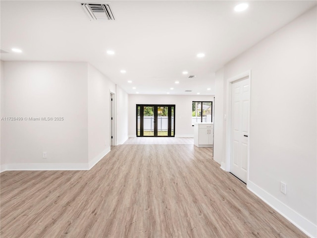 unfurnished living room with french doors and light hardwood / wood-style floors