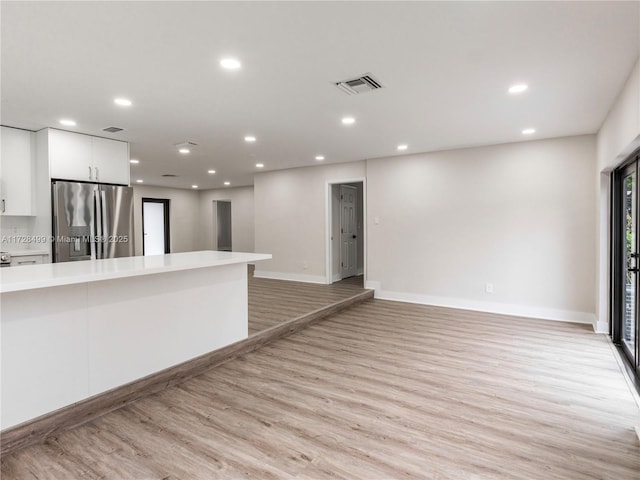 kitchen with white cabinetry, light hardwood / wood-style floors, and stainless steel fridge with ice dispenser