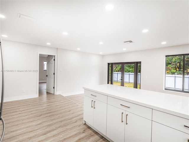 kitchen featuring white cabinetry, french doors, and light wood-type flooring