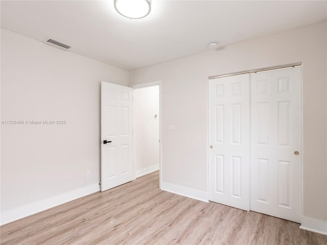 unfurnished bedroom with a closet and light wood-type flooring