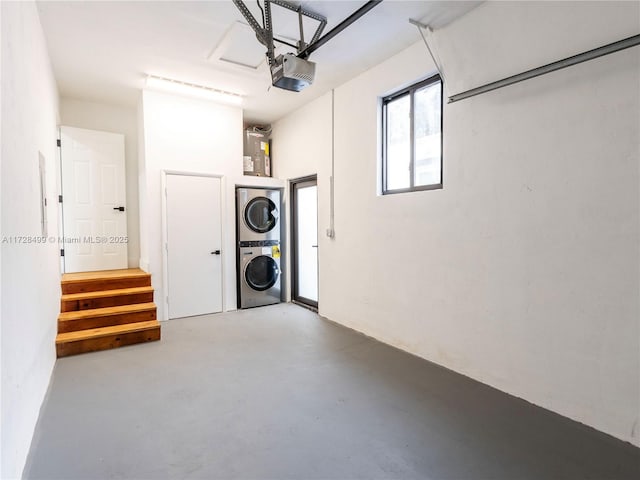 garage with stacked washer and dryer and a garage door opener