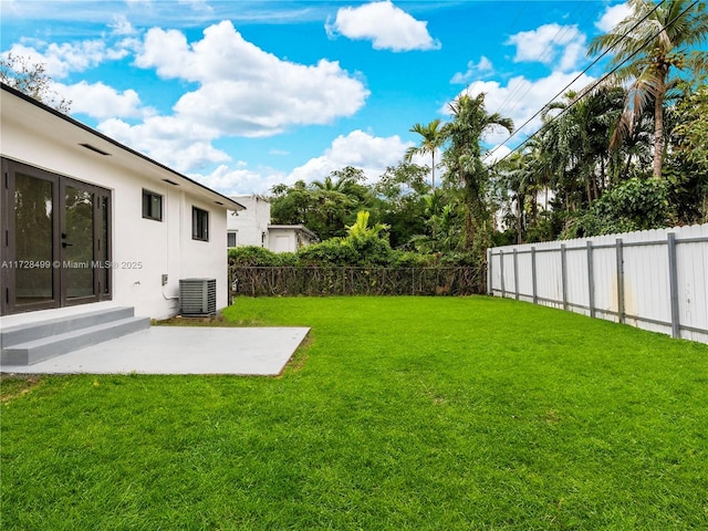 view of yard with central AC unit and a patio