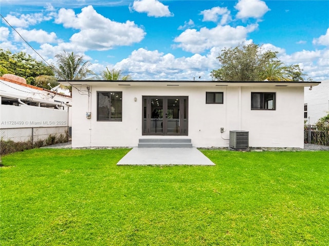 rear view of house featuring a patio, cooling unit, and a lawn