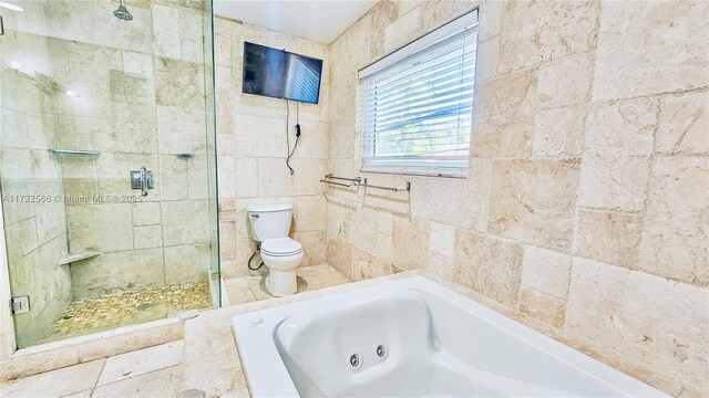 bathroom with separate shower and tub, tile walls, and toilet