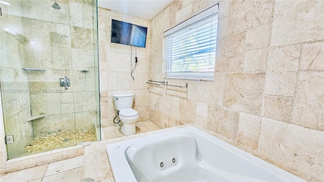 bathroom featuring toilet, independent shower and bath, and tile walls