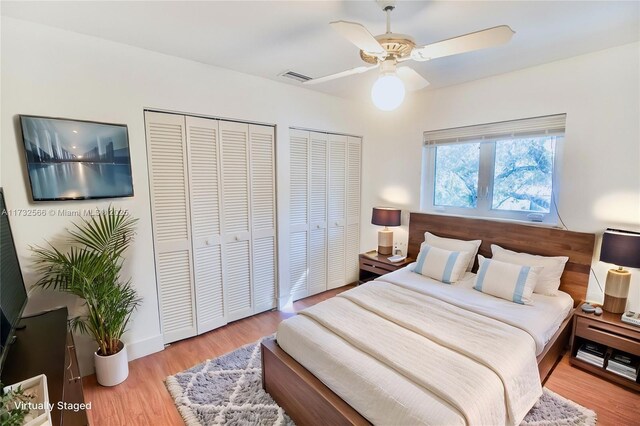 bedroom featuring two closets, ceiling fan, and light wood-type flooring