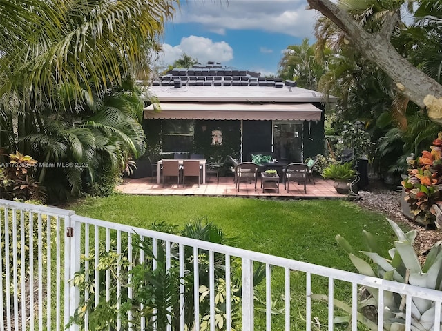 rear view of house with a patio area and a lawn