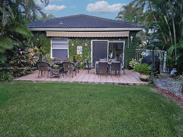 back of property featuring a yard and a patio area