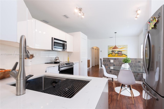 kitchen featuring white cabinetry, appliances with stainless steel finishes, dark hardwood / wood-style flooring, and decorative light fixtures