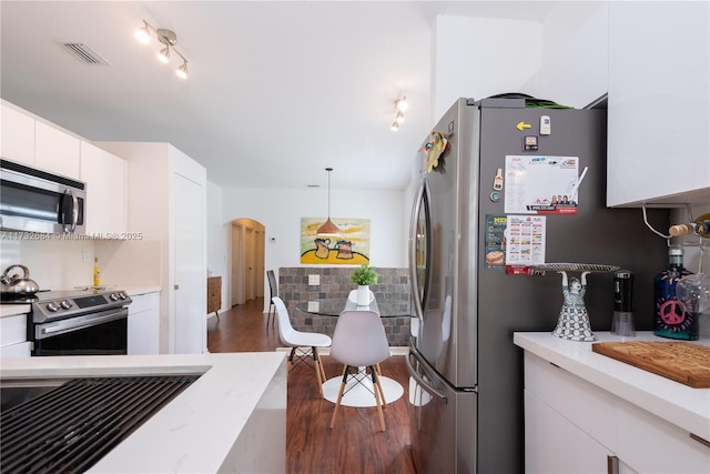 kitchen with stainless steel appliances, decorative backsplash, white cabinets, dark hardwood / wood-style flooring, and decorative light fixtures