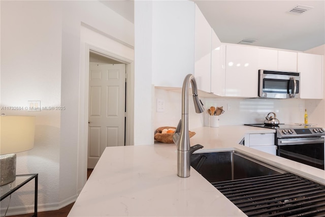 kitchen with white cabinetry and appliances with stainless steel finishes