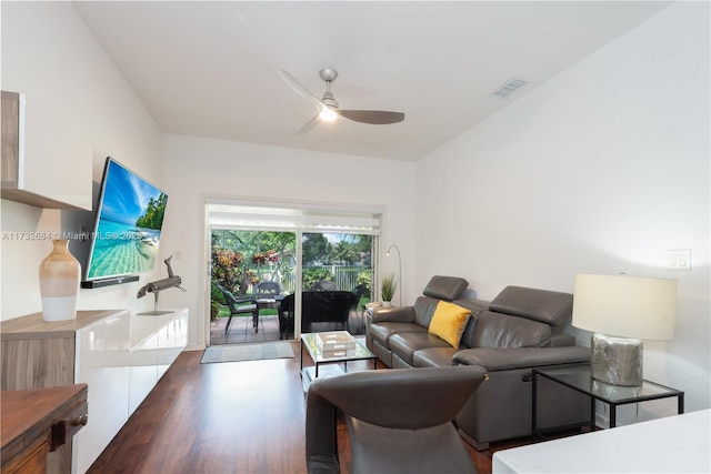 living room featuring dark wood-type flooring and ceiling fan