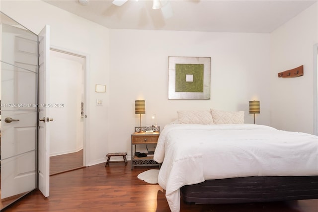 bedroom with dark hardwood / wood-style flooring and ceiling fan