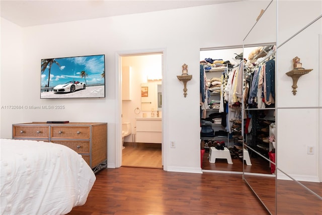 bedroom featuring dark wood-type flooring, ensuite bath, and a closet