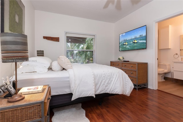 bedroom featuring ceiling fan, ensuite bathroom, and dark hardwood / wood-style flooring