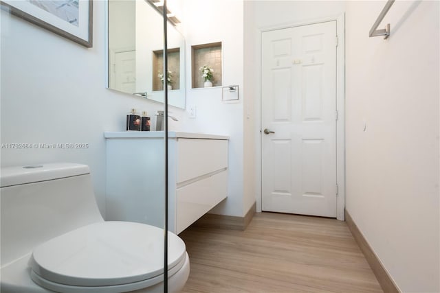 bathroom featuring vanity, hardwood / wood-style floors, and toilet