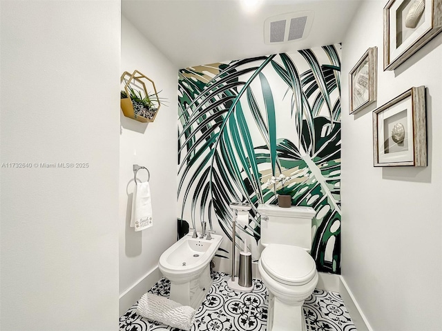 bathroom featuring a bidet, toilet, and tile patterned flooring