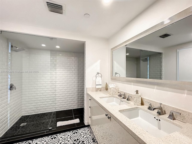 bathroom featuring tile patterned floors, vanity, and a tile shower