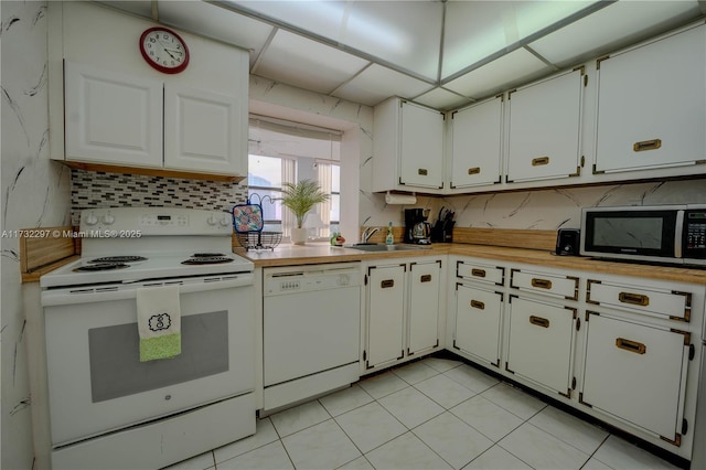 kitchen featuring sink, white appliances, light tile patterned floors, and white cabinets