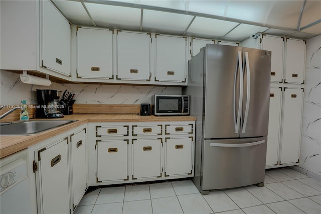 kitchen with stainless steel refrigerator, white dishwasher, sink, and white cabinets