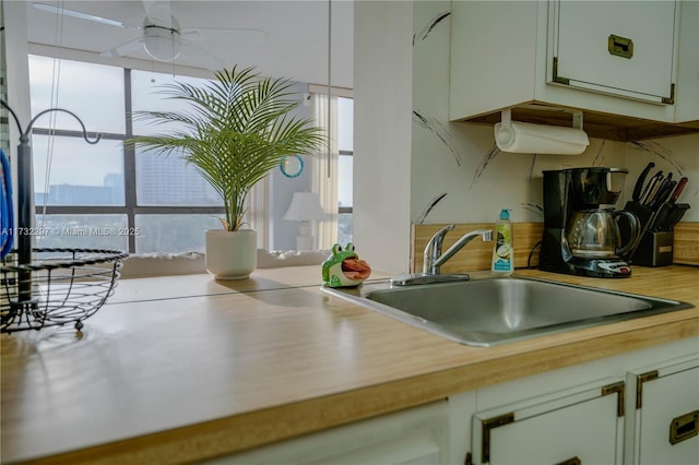 kitchen with white cabinetry, sink, plenty of natural light, and ceiling fan