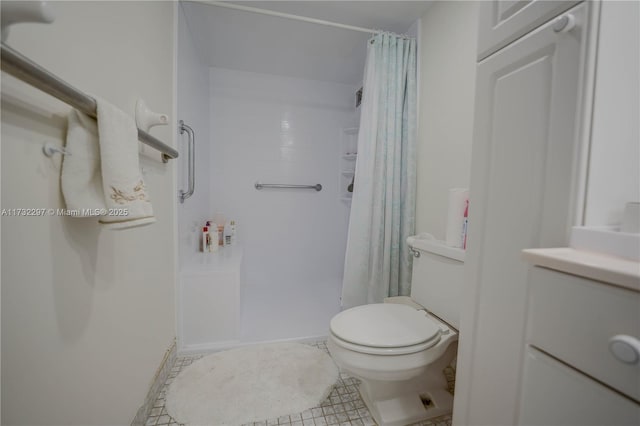 bathroom with curtained shower, tile patterned floors, and toilet