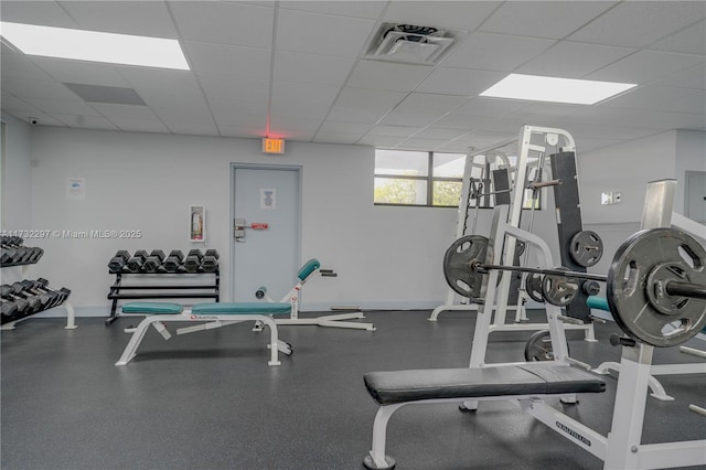 gym with a paneled ceiling and electric panel