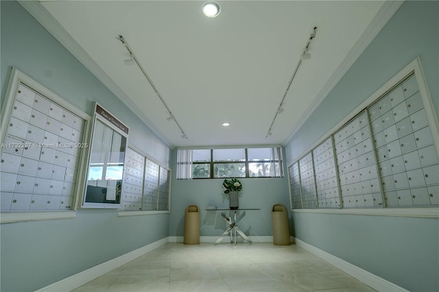 hall featuring ornamental molding, rail lighting, and mail boxes