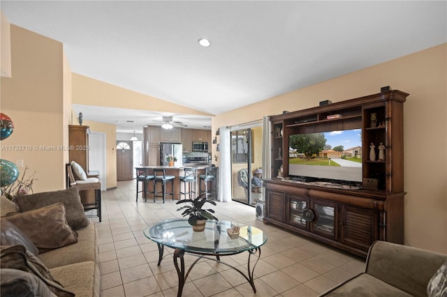 living room with ceiling fan, vaulted ceiling, and light tile patterned floors