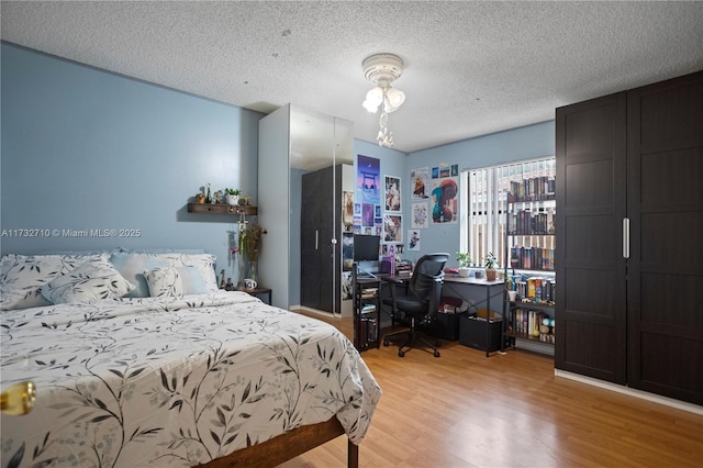 bedroom with light hardwood / wood-style floors and a textured ceiling