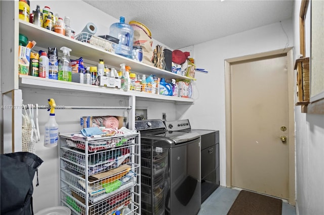 laundry room featuring washing machine and clothes dryer and a textured ceiling