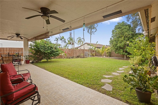 view of yard featuring ceiling fan and a patio area